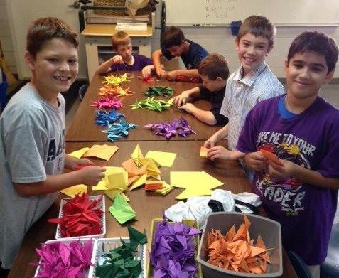 Kids fold cranes.